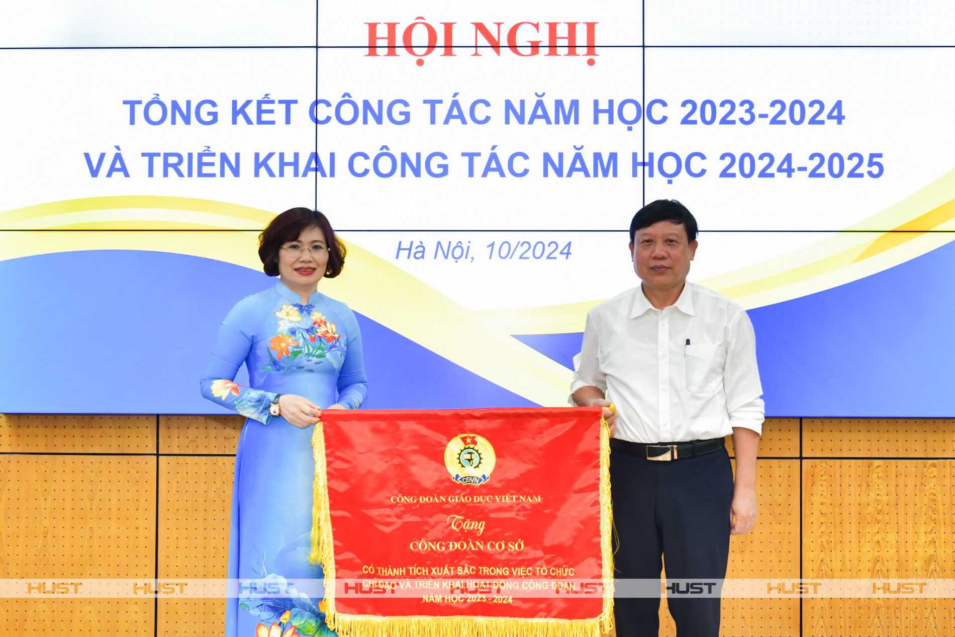 Bà Đặng Hoàng Anh - Phó Chủ tịch Công đoàn Giáo dục Việt Nam - trao cờ thi đua cho PGS. Bùi Đức Hùng – Phó Bí thư Thường trực Đảng ủy, Chủ tịch Công đoàn Cá cược xổ số
